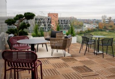 Outdoor rooftop terrace with wooden flooring and various styles of comfortable patio furniture.