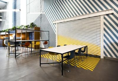 Collaborative workspace with a long white table and graphic wall art.