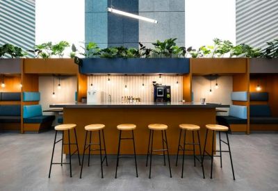 Modern cafe area with wooden stools and integrated booth seating.