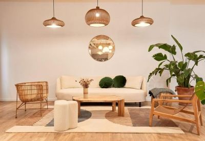 Bright communal lounge with a curved sofa, wooden furniture, and stylish globe pendant lights.