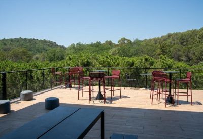 Outdoor balcony featuring red bar stools and a foosball table.