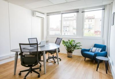 Office suite with an oval table and a blue accent armchair by the window.