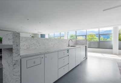 Modern kitchen and breakout area with marble countertops and a large window view.