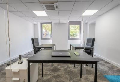 Private four-desk office suite with natural light from two windows.