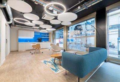 Spacious communal lounge and kitchen area with blue cabinetry and designer light fixtures.