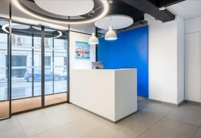 Modern reception area with a white desk and a vibrant blue feature wall.