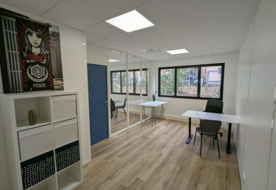 Bright private office suite with a desk, storage unit, and wooden flooring.