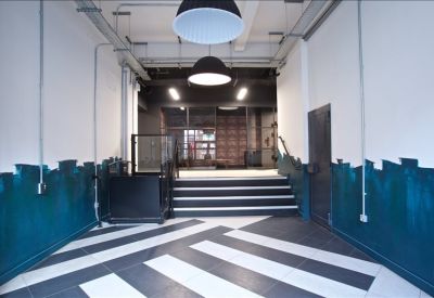 Modern building entrance featuring bold striped flooring and a stylish blue accent wall.