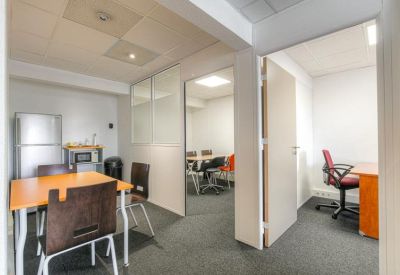 Communal break area with a dining table, chairs, and kitchenette equipment.