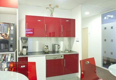 Communal kitchen area with vibrant red cabinetry and modern appliances.
