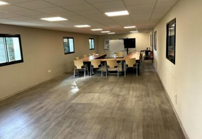 Spacious meeting room with wooden chairs and natural light from multiple windows.