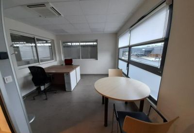 Private corner office with two desks and large windows.