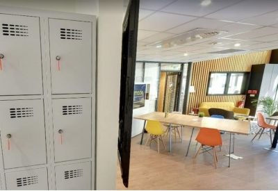 Bank of grey lockers in a bright open-plan office space.