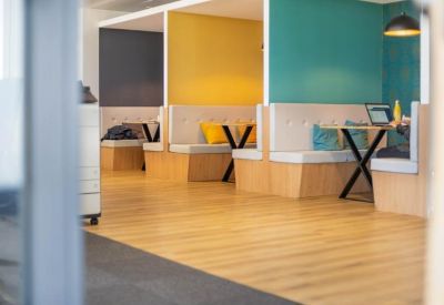 Modern breakout area with colorful booths and built-in seating.