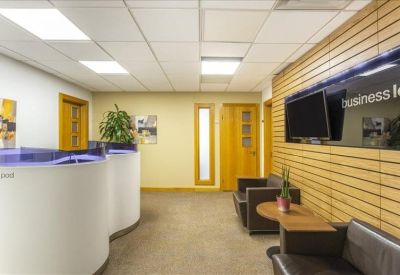Modern reception area with curved desks, wooden wall panels, and lounge seating.