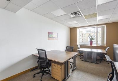 Bright corner office with wooden desks and street views.