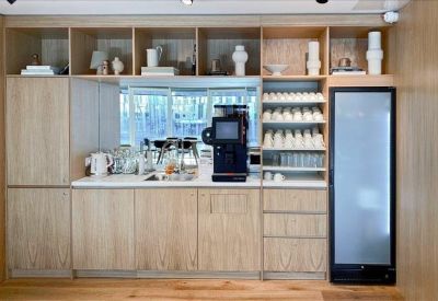 Coffee station area with light wood cabinetry and built-in shelving.
