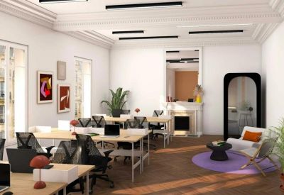 Bright open-plan office with white walls, multiple workstations, and a private phone booth.