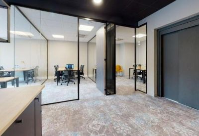 Modern entrance hallway with black accents and glass doors leading to office suites.