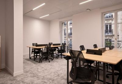 Open-plan office space with multiple desks and chairs