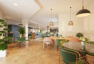Elegant dining and coworking area with green and pink velvet chairs.