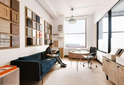 Private office suite featuring a blue sofa and a wall display of wood and color samples.