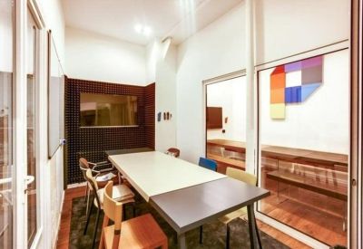 Private meeting room with a large white table and soundproof wall panels.