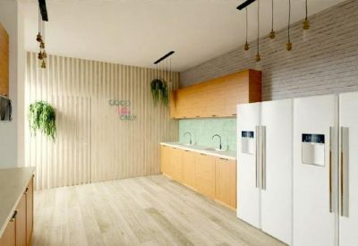 Bright modern kitchen area with wood cabinetry, white refrigerators, and brick accent wall.