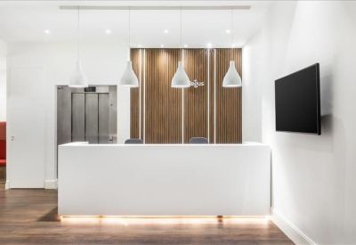 Minimalist white reception desk with wood-paneled feature wall and modern pendant lighting.