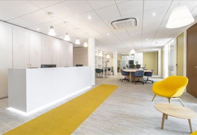 Bright reception area featuring a long white desk and a vibrant yellow armchair.