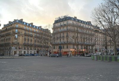 Exterior view of the ornate Haussmann-style stone buildings on a wide city street.