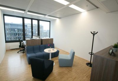 Casual breakout area with blue sofas and a small round meeting table.