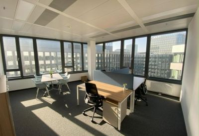 Private office suite with two desks and large windows overlooking the city.