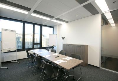 Bright conference room with a long wooden table and two mobile whiteboards.