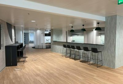 Long kitchen counter with bar seating under modern black pendant lights.