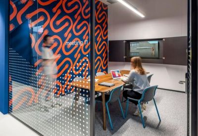 Private meeting room featuring a bold patterned wall and blue chairs.
