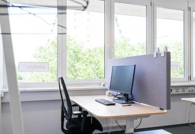 Dedicated workstation with a dual-monitor setup and grey acoustic desk divider.