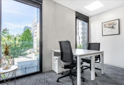 Private two-person office with floor-to-ceiling windows and garden views.