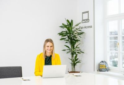 Bright breakout space with a potted plant and natural light from a large window.