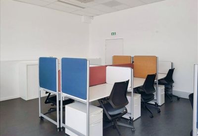 Shared workspace with colorful blue and orange privacy screens between desks.