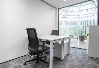 Internal private office with two desks and a large window overlooking a glass atrium.