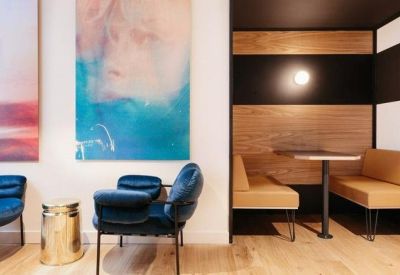 Cozy meeting booth with tan leather seating and vibrant blue velvet armchairs.