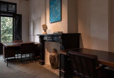 Classic office with a dark fireplace, art piece, and two desks.