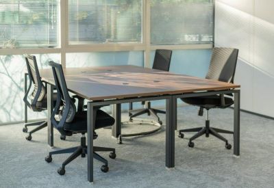 Empty office area with a table and four swivel chairs.