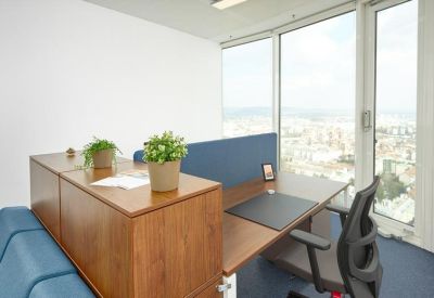 Modern private office workstation with wooden cabinetry and views over the city.