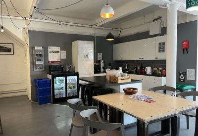 Modern communal kitchen and breakout area with a central island and dining table.