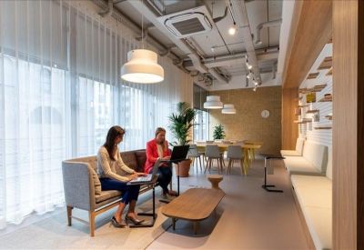 Spacious lounge area with a grey sofa, wooden coffee table, and exposed ceiling.