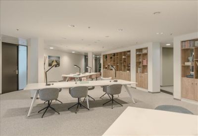Long white conference table in a bright meeting room with grey chairs.
