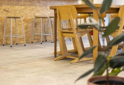 Bright break area featuring an OSB-clad counter and a wooden dining table with chairs.