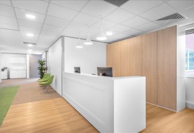 Modern white reception desk with wood-paneled walls and warm floor tones.
